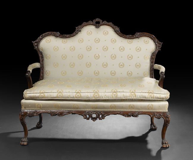 George III-Style Mahogany Settee: George III-Style Mahogany Settee, 19th century, in the Chippendale rococo taste, the padded shaped and domed back within a foliate-carved frame, joined by padded arms to the cushioned seat, raised abo