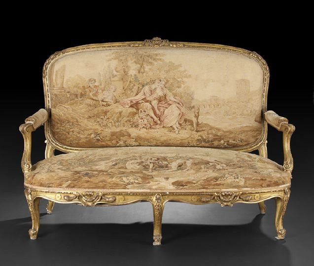 Good French Giltwood Settee: Good French Giltwood Settee, fourth quarter 19th century, in the Louis XV taste, the padded rounded rectangular back surmounted by a shield- and swag-carved crest, joined by outscrolled padded arms to
