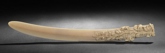 Carved Ivory Page Turner: Carved Ivory Page Turner, first half 20th century, of slightly curved shape following the curve of the tusk with flattened blade, the handle carved in relief on both sides with vining roses composed o
