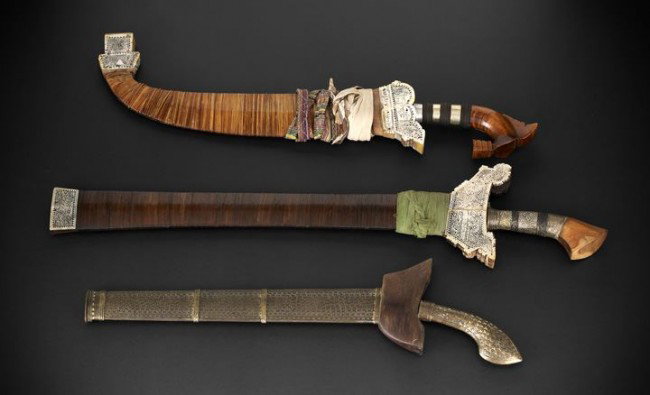 Three Philippine Moro Tribe Edged Weapons: Collection of Three Philippine Moro Tribe Edged Weapons, including two krisses, both first quarter 20th century, the first with a wavy 15-1/2" blade, with brass hilt, the scabbard with exotic wood cap