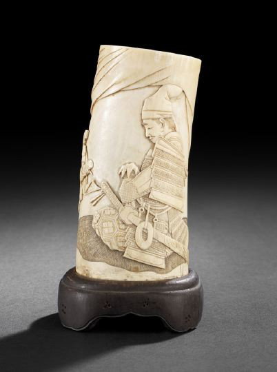 Japanese Carved Ivory Section of an Elephant Tusk: Japanese Carved Ivory Section of an Elephant Tusk, Meiji Period (1868-1912), carved in low relief as a seated samurai with a sword and attended by a kneeling servant presenting a scroll, presented on 