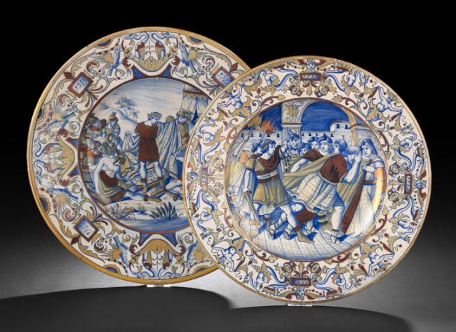 Group of Two Iberian Faience Circular Platters: Group of Two Iberian Faience Circular Platters, early 20th century, each richly polychromed and featuring a classical battle scene within an elaborate mask and scrolling foliate border, dia. 15-1/2" a