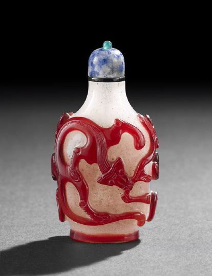 Good Chinese Overlay Glass Snuff Bottle: Good Chinese Overlay Glass Snuff Bottle, 19th century, the camphor glass body overlaid in vibrant red and carved as two hydra dragons, with a sodalite top, h. 2-7/8".