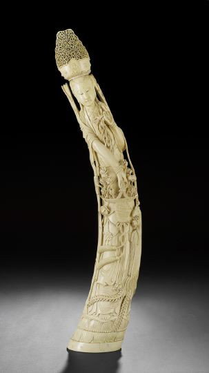 Chinese Carved Ivory Figure of a Female Deity: Large and Impressive Chinese Carved Ivory Figure of a Female Deity, 20th century, carved in high relief following the curve of the tusk as a female deity holding a basket of lotus blossoms with an att