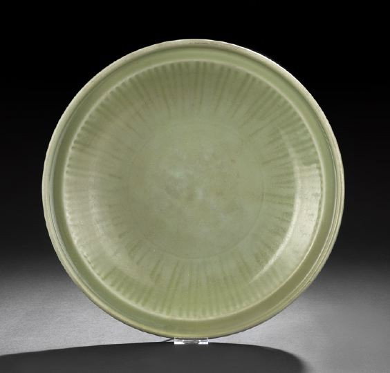 Large Chinese Celadon Serving Platter: Large Chinese Celadon Serving Platter, Ming Dynasty (13368-1644), of circular outline with raised rim and incised ribbed decoration, the red fired pottery glazed all over in a rich celadon glaze, dia.