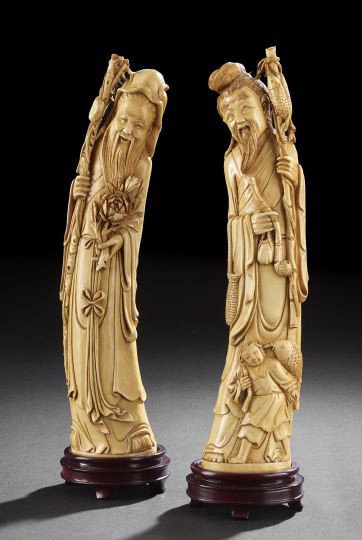 Pair of Chinese Ivory Figures of Immortals: Pair of Chinese Stained Ivory Figures of Immortals, late 19th century, each figure carved following the curve of the tusk, one figure wearing a cowl holding a staff with peaches in one hand and peonie