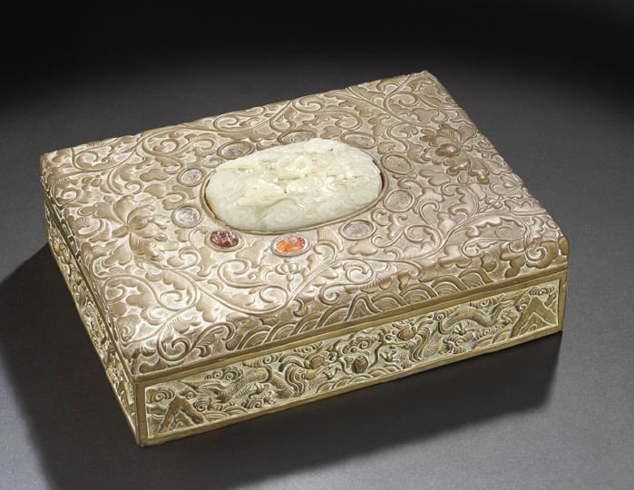 Chinese Brass, Jade and Hardstone Box: Chinese Brass, Jade and Hardstone Box, first half 20th century, the metal body with scrolling foliate decoration and a central carved white jade oval plaque surrounded by carved carnelian cabochons (l