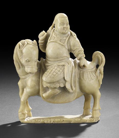 Chinese Carved Soapstone Figure of Guandi: Chinese Carved Soapstone Figure of Guandi The God of War and Literature, first half 20th century, the even colored pea green stone carved as the god in armor astride his steed, h. 8-1/2", l. 7-1/4". P