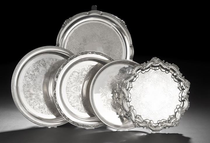 Five Circular Silverplate Platters: Five Circular Silverplate Platters, mid-20th century, all with rococo engraved plateau, including an International Silver example with gadrooned rim, dia. 14-1/4", a William Rogers example with rococo