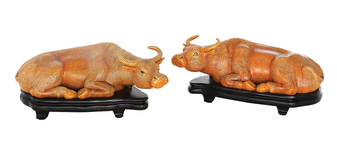 Pair of Chinese Pottery Water Buffalo on Stands: Large Pair of Chinese Pottery Water Buffalo on Stands 20th century, with a dark loquat glaze, figures reclining with their heads turned in opposite directions, raised on molded and ebonized wooden bas