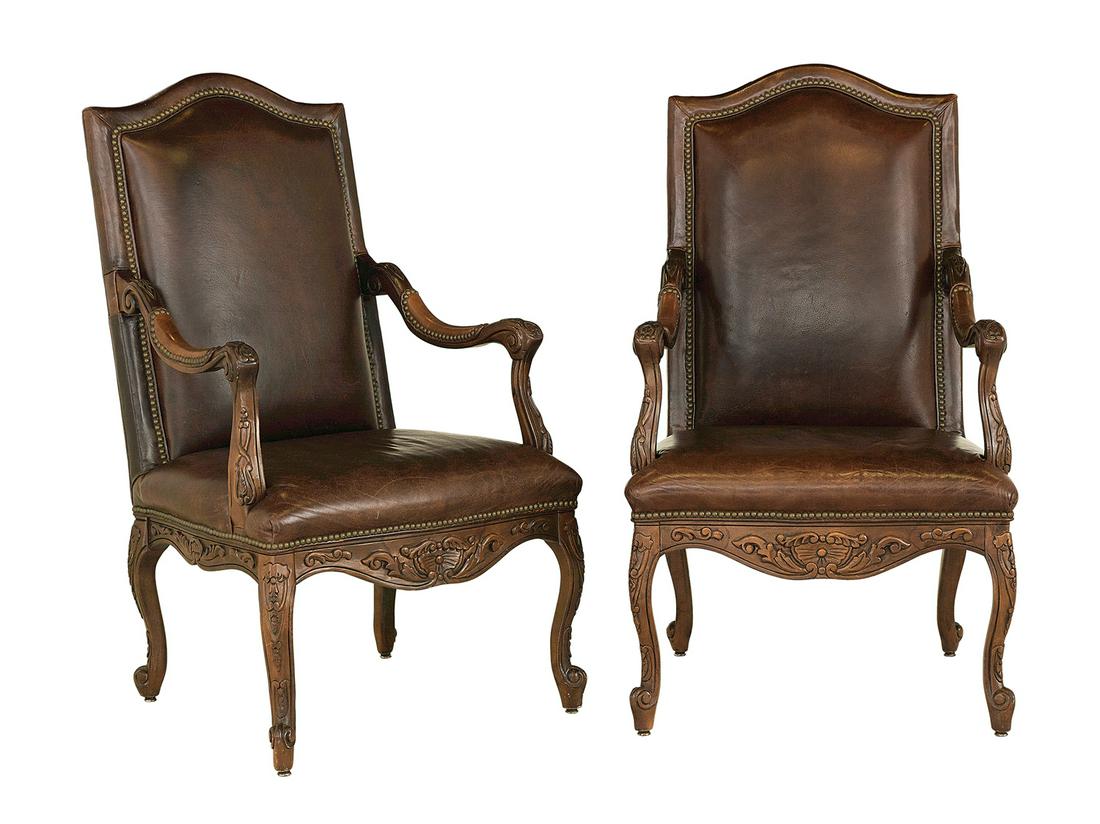Louis XV-Style Leather-Upholstered Armchairs: Pair of Louis XV-Style Fruitwood and Leather-Upholstered Armchairs each with a padded and domed leather back with brass tack accents, joined by downswept arms to the padded seat, raised above a shaped