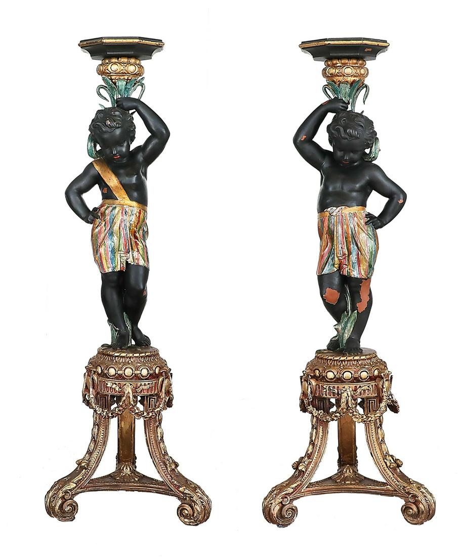 Pair of Italian Polychrome Blackamoors: Pair of Italian Polychrome Blackamoors in the Venetian manner, each a youthful figure in a colorful skirt, holding aloft an octagonal torchere and standing on a molded circular base raised on three be