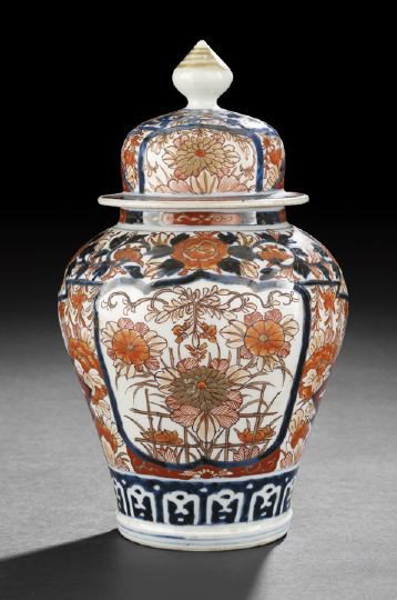 Japanese Imari Porcelain Covered Storage Jar,: Japanese Imari Porcelain Covered Storage Jar, 19th century, of baluster-form with domed cover and pointed finial, decorated in dark underglaze blue, iron-red and gilding with shaped reserve panels of 