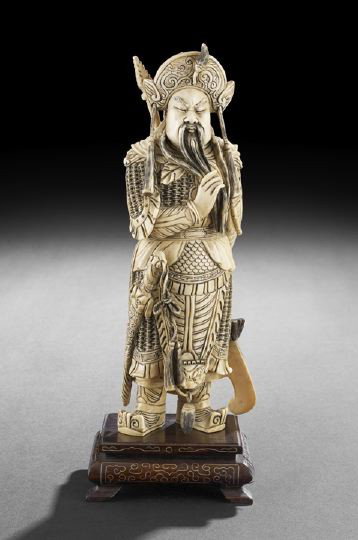 Chinese Ivory Figure of Guandi: Chinese Carved Ivory Figure of Guandi the God of War and Literature, elaborately carved as a standing figure clad in military armor and holding a halberd, wooden stand with silver wire inlay, h. 11-1/