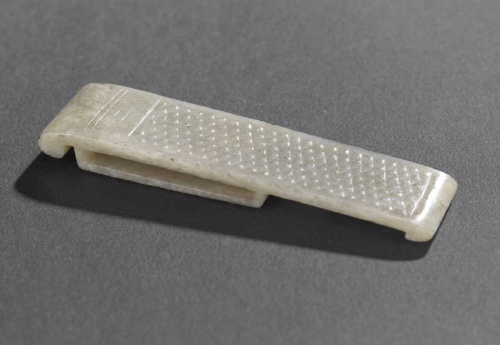 Chinese Carved Celadon Jade Sword Slide,: Chinese Carved Celadon Jade Sword Slide, 19th century, of rectangular outline with in-curved ends, the reverse with a rectangular opening and a square boss, the face carved with a panel of raised dots