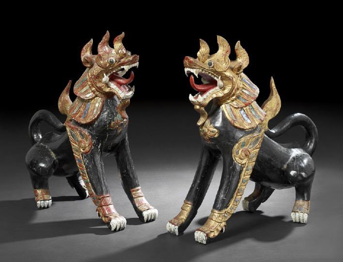 Pair of Thai Painted Wooden Guardian Temple Dogs: Pair of Thai Painted and Mirrored Wooden Guardian Temple Dogs, each fierce creature seated on its haunches with open snarling mouth, the black painted bodies with red, gold and white painted details a