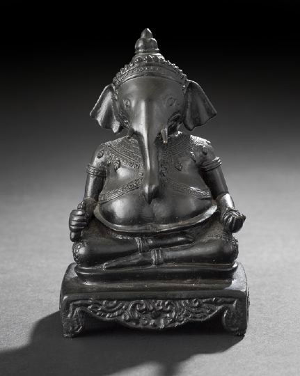 Indian Cast-Bronze Figure of the God Ganesh,: Indian Cast-Bronze Figure of the God Ganesh, first quarter 20th century, cast as the seated figure of the elephant-headed god with outstretched hands wearing a crown and elaborate embroidered robe, se