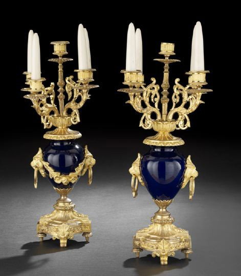 Pair of Continental Belle Epoque Candelabras: Pair of Continental Belle Epoque Five-Light Candelabras, fourth quarter 19th century, consisting of bleu marine porcelain urns on a Louis XV-style base, with griffin head ring pull handles, candle cup