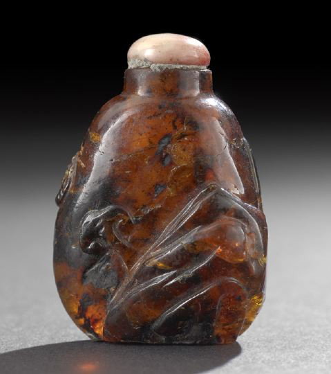 Chinese Carved Amber Pebble Snuff Bottle,: Chinese Carved Amber Pebble Snuff Bottle, carved in relief as an entwined sinuous dragon and a rocky outcrop with a spray of ling chih fungus, h. 2-1/8".