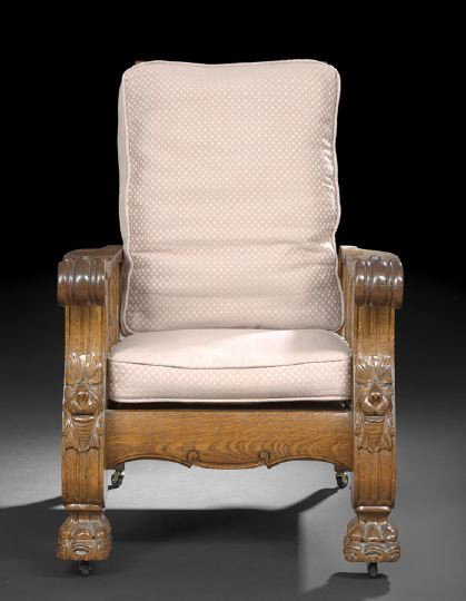 American Late Victorian Oak Morris Chair: American Late Victorian Oak Morris Chair of Late Classical Inspiration, the reclining back fitted with a cast and stamped iron adjustment mechanism, the arm terminating in scroll-carved hand-rests and