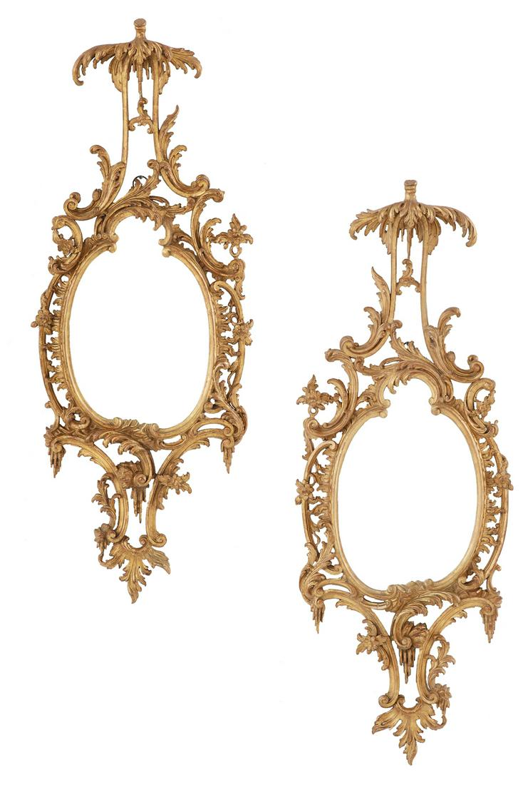Pair of Handsome English Giltwood Mirrors: Pair of Handsome English Giltwood Mirrors ca. 1900, in the rococo taste, the oval mirror plates set into giltwood surrounds, decorated with rocaille and scrollwork, the central crests with canopies an