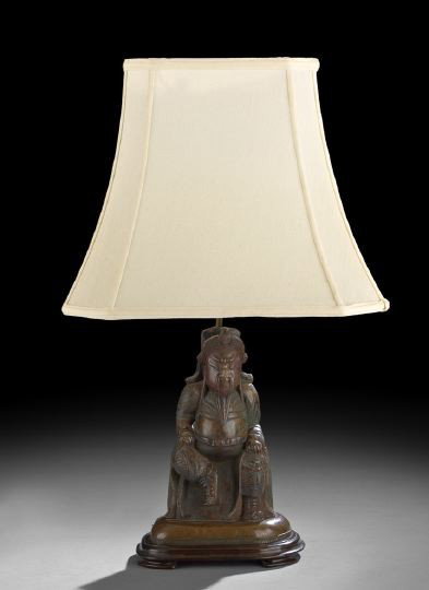 Chinese Bronze Figure of Guan Di: Chinese Bronze Figure of Guan Di, 19th century, now mounted as a lamp, the seated figure dressed in armor with traces of painted details, mounted on a copper and wooden base with a post at the back fo