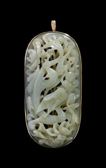 14 Karat Yellow Gold and Jade Pendant: Large Fourteen Karat Yellow Gold and Jade Pendant, of rectangular outline with domed ends, the yellow gold mount set with a dimensional celadon jade plaque carved as a dragon among flowering peonies c