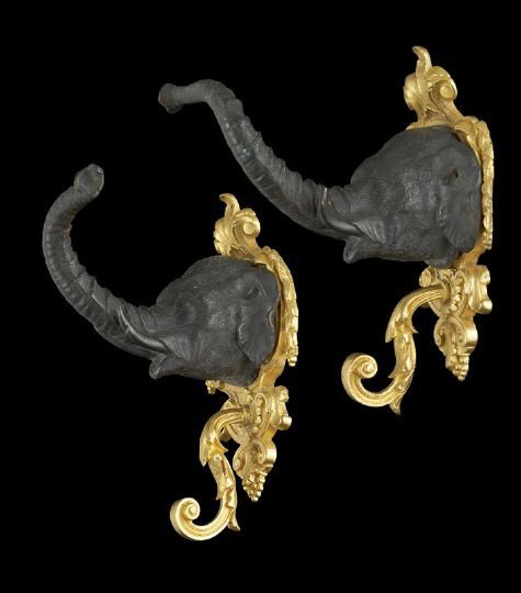 Diminutive Pair of French Double Wall Hooks: Elegant, Diminutive Pair of French Double Wall Hooks, in the form of bronze-patinated elephant masques on gilt-lacquered brass backplates, in the Louis XVI style, the elephants' trunks raised to form 