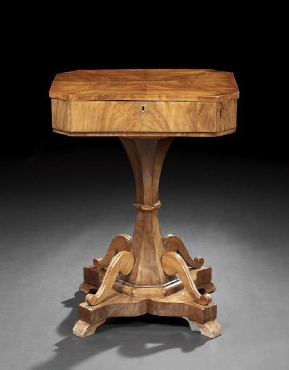 Biedermeier Walnut Work Table: Biedermeier Walnut Work Table, second quarter 19th century, the canted rectangular top quarter-veneered and opening to a variety of lidded compartments centering a central storage section, raised on a