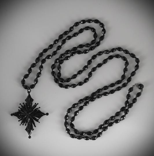 Victorian Jet Mourning Necklace with Pendant Drop: Victorian Jet Mourning Necklace with Pendant Drop, ca. 1880, composed of a long necklace of oval faceted beads with a cruciform drop overlaid with faceted rays having circular terminals.