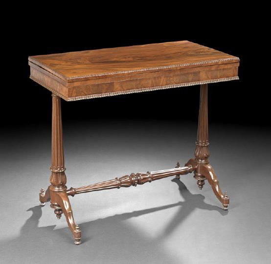 American Late Classical Mahogany Games Table: American Late Classical Mahogany Fold-Open Games Table, mid-19th century, New York, the flame mahogany top having a ribbon-molded edge and supported by turned-and-carved-standards on each end and join