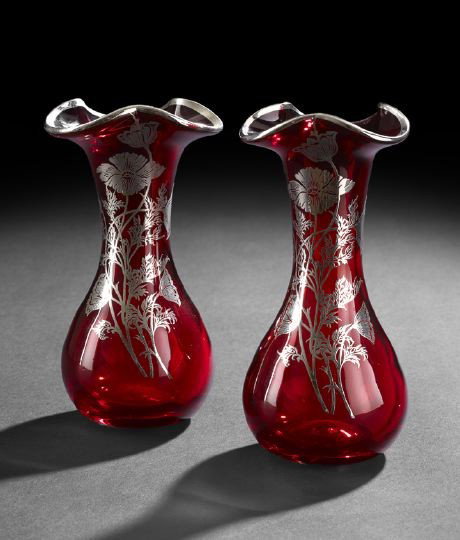 Pair of Silver Overlay Ruby Glass Vases: Pair of Silver Overlay Ruby Glass Vases, early 20th century, each with a flaring and scalloped lip, the body adorned with a floral spray depicting a variety of flowers amongst twisting vines and folia