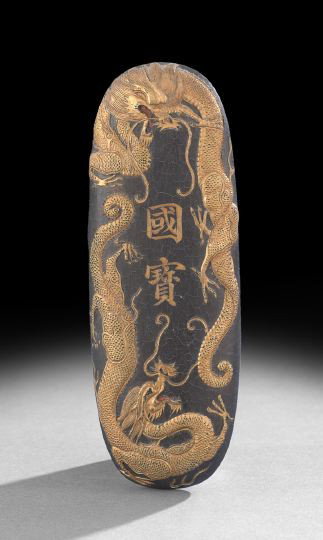 Chinese Oval Form Black and Gilt Ink Stick: Chinese Oval Form Black and Gilt Ink Stick, the elongated oval with low relief molding on the face depicting two dragons and calligraphy, the reverse with molding of clouds and a Qianlong reign mark, 