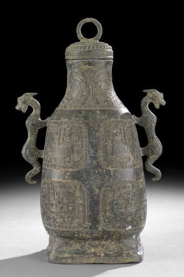 Chinese Bronze Vessel: Chinese Bronze Vessel, in the archaic-style, the circular lid with a ring finial above a graduated body with applied dragon handles and decorative panels with stylized animals, h. 16-1/4".