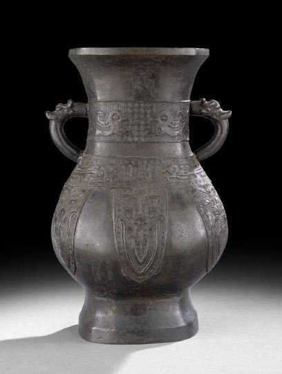 Chinese Bronze "Hu" Vase with Zoomorphic Handles: Chinese Cast Bronze "Hu" Vase with Zoomorphic Handles, Ming Dynasty (1368-1644), of flattened baluster form with molded archaic decoration in horizontal bands and pendant lappets, the handles in the f