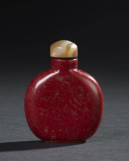 Chinese Carved "Chicken Blood" Stone Snuff Bottle: Chinese Carved "Chicken Blood" Stone Snuff Bottle, of flattened round shape the rich red stone with scattered translucent brown matrix inclusions, h. 2-7/8".