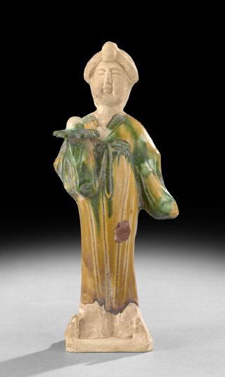 Chinese Glazed Pottery Figure of a Court Lady: Chinese Glazed Pottery Tang-Style Figure of a Court Lady, the standing figure clad in tri-colored glazed robes with elaborate hairdo and holding an offering dish in one hand, h. 10-1/4".