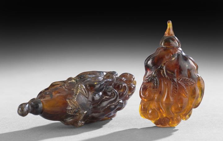 Group of Two Amber Chinese Snuff Bottles: Group of Two Amber Chinese Snuff Bottles, each of dark brown amber, both carved in the form of a Buddha's Hand citron with foliage, h. 2-1/4" to 3".