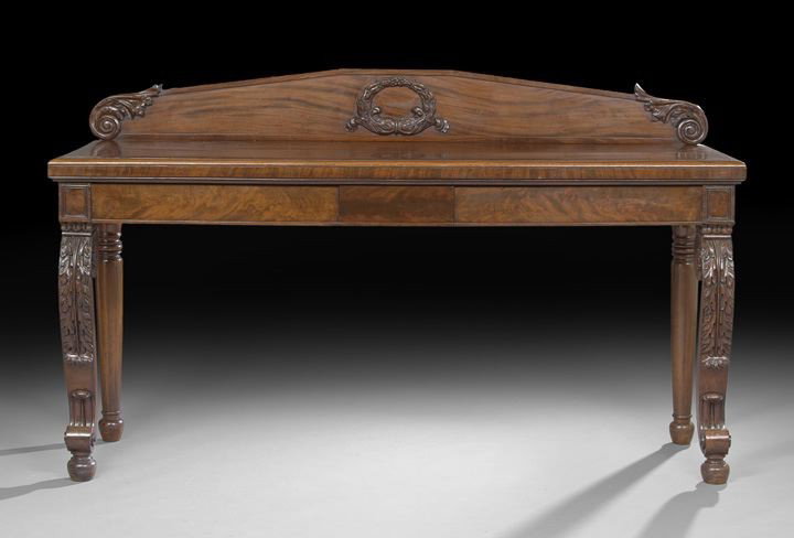 Regency Mahogany Sideboard: Regency Mahogany Sideboard, second quarter 19th century, having a wreath-carved backsplash with foliate-carved and scrolled ends, the thick overhanging top above a paneled frieze fitted with two side-