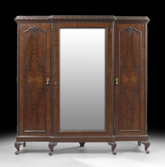 Edwardian Figured Mahogany Triple Door Armoire: Edwardian Figured Mahogany Triple Door Armoire, c. 1900, having a central paneled door with highly figured mahogany and flanked by mirrored doors on each side, the interior fitted with sliding drawers