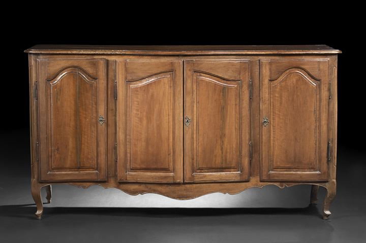 Provincial Louis XV Walnut Buffet: Provincial Louis XV Walnut Buffet, late 18th century, possibly Italian, the long rectangular top with a molded edge and shaped front, above a conforming case fitted with four cupboard doors, all inset