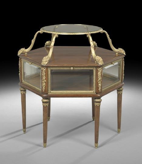 Louis XVI-Style Mahogany Tiered Center Table: Unusual Louis XVI-Style Mahogany Tiered Center Table, the circular upper tier with an inset glass surface, joined by six ormolu cornucopia supports to the hexagonal base, fitted with six beveled drop-