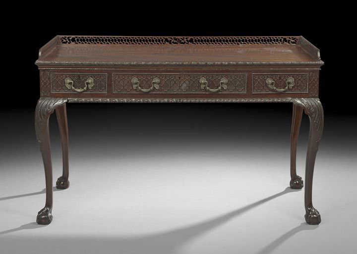 George III-Style Figured Mahogany Writing Desk: Fine George III-Style Figured Mahogany Writing Desk, fourth quarter 19th century, after a design by Thomas Chippendale (1718-1779), having a pierced fretwork gallery above a highly figured writing sur