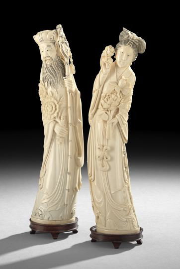 Pair of Chinese Carved Ivory Figures: Pair of Chinese Carved Ivory Figures, 20th century, carved following the curve of the tusks as male and female deities, the male with an official cap and carrying a staff, the female carrying groups o