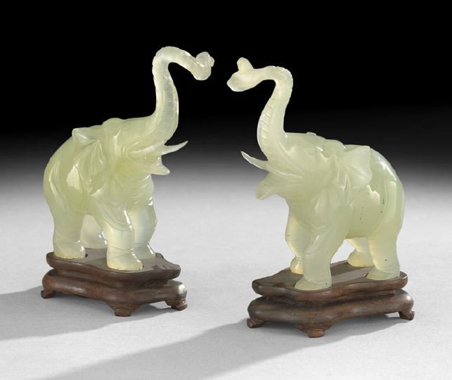 Paid of Chinese Serpentine Elephants on Stands: Paid of Chinese Carved Serpentine Elephants on Stands, 20th century, each carved in pale green translucent stone as figures of trumpeting elephants with raised trunks, fitted wooden stand, h. 5-1/2", 