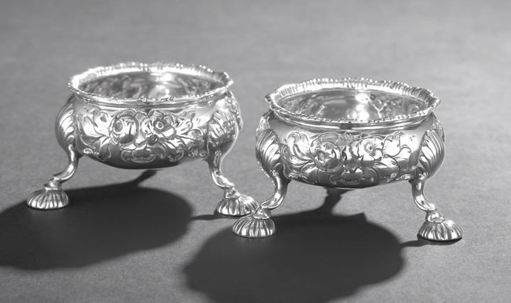 Pair of George III Sterling Silver Salt Cellars: Pair of Early George III Sterling Silver Salt Cellars, hallmarked London, 1765-1766, by Daniel & Robert Hennell, each of bulbous circular form decorated with a repousee flowers centering a rococo cart