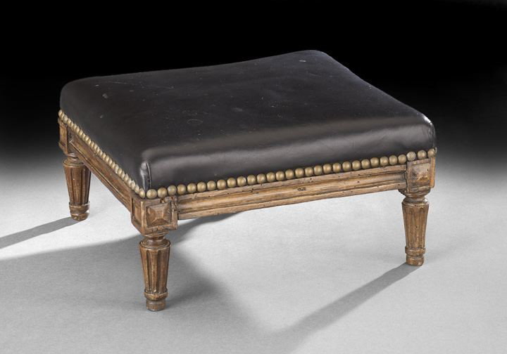 Provincial Louis XVI-Style Fruitwood Footstool: Provincial Louis XVI-Style Fruitwood Footstool, early 20th century, the padded square top above a ribbon-carved frieze, raised on tapering circular fluted legs ending in toupie feet, h. 9", w. 15-1/2"