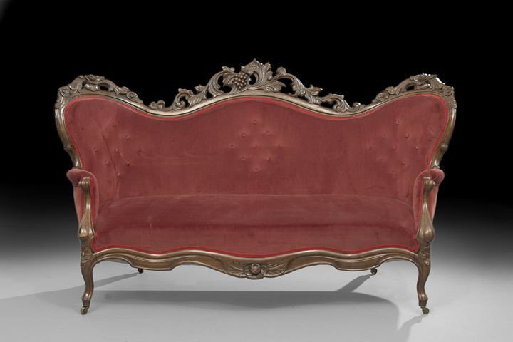 American Rococo Revival Walnut Settee: American Rococo Revival Walnut Settee, third quarter 19th century, the frame having a pierced an carved floral crest with a cluster of grapes in the central back, covered in a maroon velvet upholstery