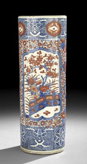 Japanese Imari Porcelain Umbrella Stand: Japanese Imari Porcelain Umbrella Stand, 20th century, the cylindrical porcelain body enameled in underglaze blue and iron-red with reserve panels of garden scenes against a stylized floral ground, h.