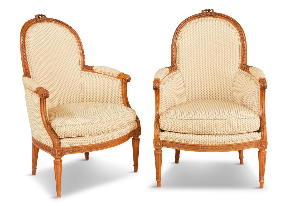 Pair of Louis XVI-Style Fruitwood Bergeres: Pair of Louis XVI-Style Fruitwood Bergeres early 20th century, each with a padded and domed back within a ribbon-carved frame surmounted by a floral crest, joined by beaded and acanthine-carved, padde